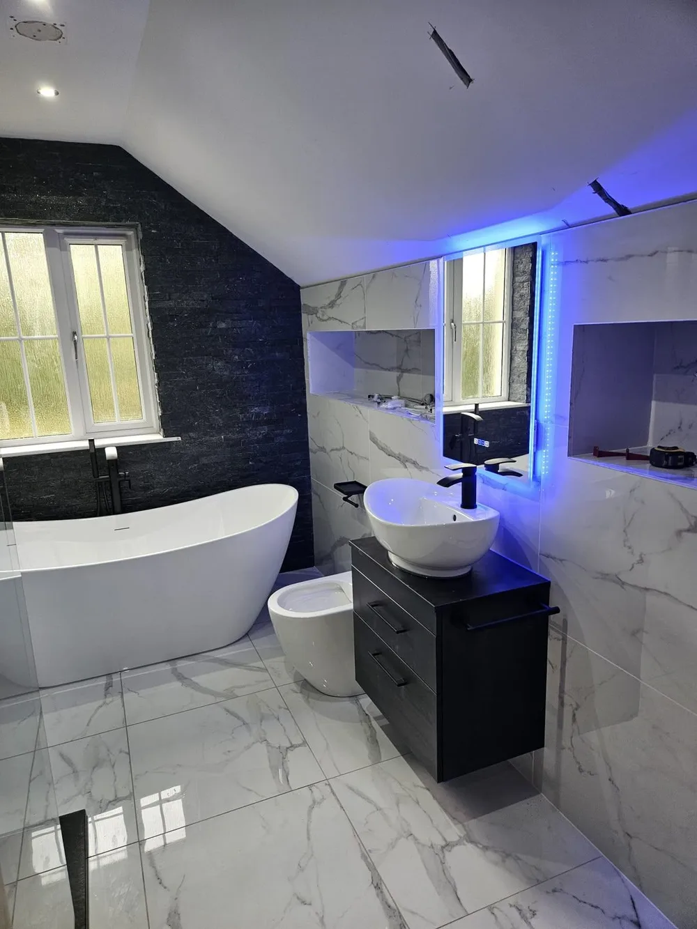 A finished ensuite by Premier Plumbing, with a freestanding bath and a blue-lit LED mirror