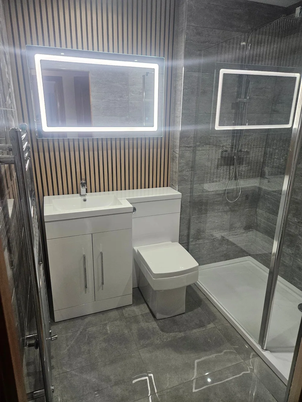 Slatted oak panelling behind a wall-hung vanity